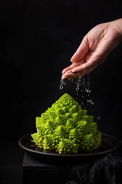 Mão Mulher Derrama Água Repolho Romanesco Fundo Escuro — Fotografia de Stock