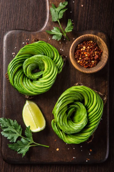 Toast Mit Avocadorosen Auf Einem Holzschneidebrett Ansicht Von Oben — Stockfoto