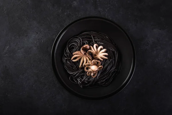 鱿鱼墨意大利面与章鱼在黑碗 顶部视图 — 图库照片