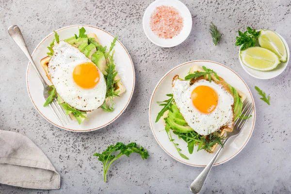 おいしいワッフルの朝食 上面にアボカド ルッコラと揚げ卵 — ストック写真