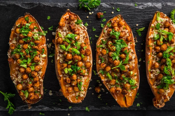 Rostad Sötpotatis Fyllda Med Kikärtor Och Quinoa Ovanifrån Svart Bakgrund — Stockfoto