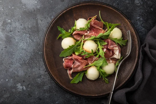 Parmaskinka Melon Och Ruccola Sallad Mörk Bakgrund Ovanifrån — Stockfoto