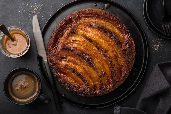 Kopfüber Liegender Bananenkaramellkuchen Schwarzer Hintergrund Draufsicht — Stockfoto