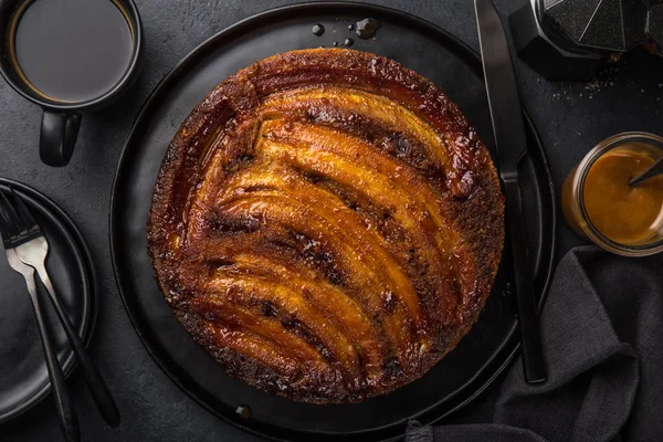 Kopfüber Liegender Bananenkaramellkuchen Schwarzer Hintergrund Draufsicht — Stockfoto