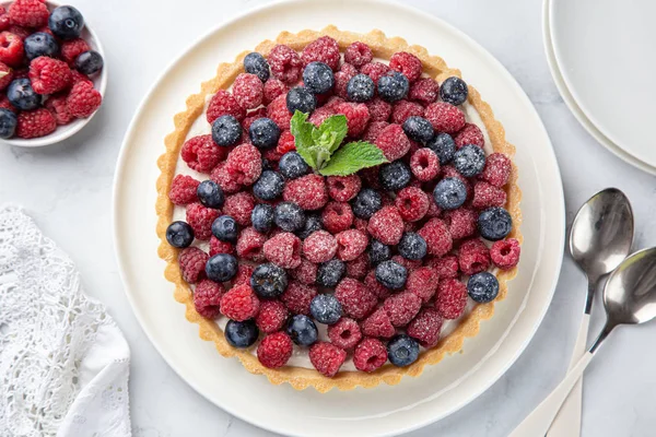 Tarte aux bleuets et framboises sur fond de marbre blanc — Photo