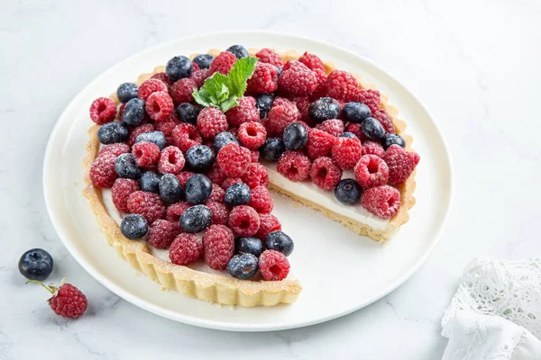 Tarte aux bleuets et framboises sur fond de marbre blanc — Photo