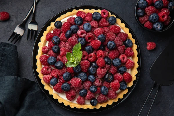 Tarte aux bleuets et framboises sur fond noir — Photo