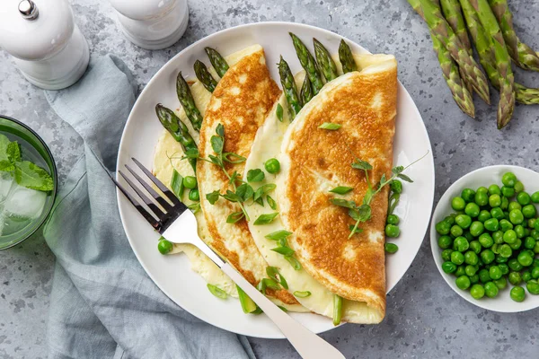 Omlet ze szparagi i zielonym grochem na białej płycie — Zdjęcie stockowe