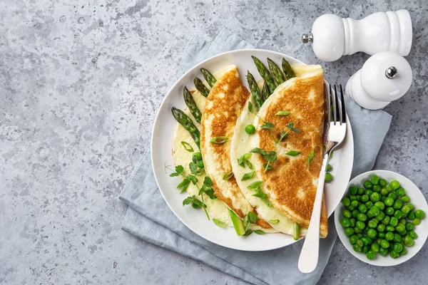 Omelette with asparagus and green peas on white plate — Stock Photo, Image