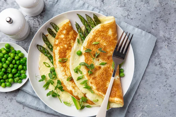 Tortilla con espárragos y guisantes verdes en plato blanco para el desayuno —  Fotos de Stock