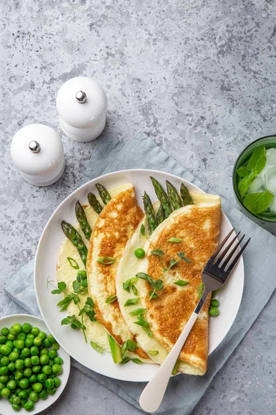 Tortilla con espárragos y guisantes verdes en plato blanco para el desayuno —  Fotos de Stock