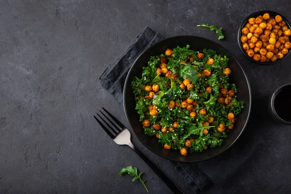 Vegan healthy kale and roasted chickpeas salad in black bowl — Stock Photo, Image