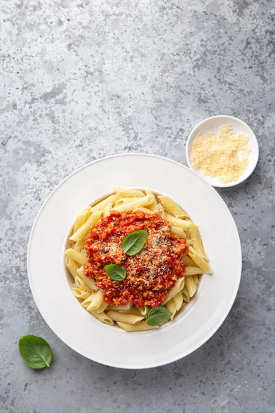 Pasta de penne con pausa boloñesa y queso parmesano en pl blanco — Foto de Stock