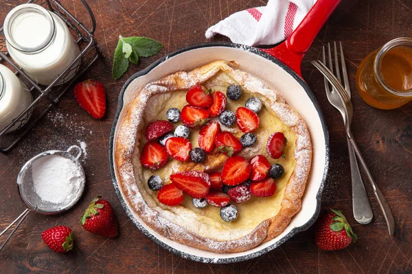 Panqueque holandés con bayas frescas en sartén roja para el desayuno — Foto de Stock