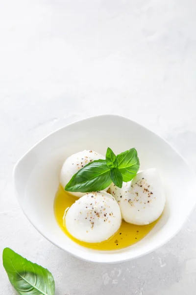 Mozzarella cheese with olive oil and basil in bowl — Stock Photo, Image