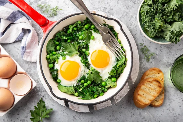 Здоровий сніданок. смажені яйця з капустою, шпинатом та зеленим горохом — стокове фото