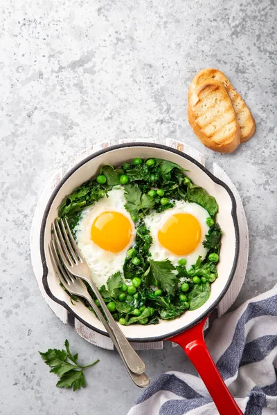 Здоровый завтрак. жареные яйца с капустой, шпинатом и зеленым горохом — стоковое фото