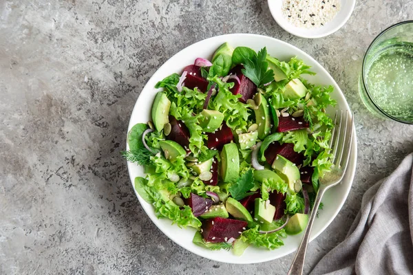 Hälsosam vegansk avokado-och betor sallad i vit skål — Stockfoto