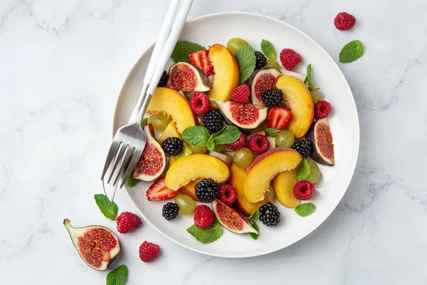 Sweet fruit and berry salad on white plate — Stock Photo, Image