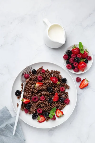 Ζυμαρικά με γλυκιά σοκολάτα fusilli με φρέσκα μούρα σε λευκό πιάτο — Φωτογραφία Αρχείου