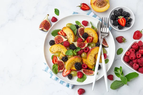 Summer fruit and berry salad with chia seeds on white plate — ストック写真