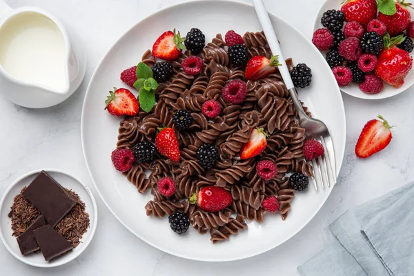 Chocolate fusilli pasta with fresh berry on white plate — Stock Photo, Image