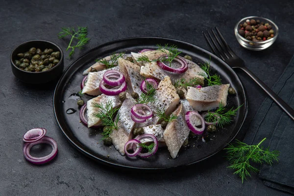 Ingemaakte Haring Met Rode Kappertjes Dille Zwarte Plaat Selectieve Focus — Stockfoto