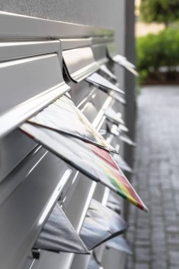 Modern mailboxes filled of leaflets. Business and advertising concepts. Shallow depth of field. clipart