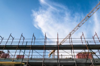 İnşaat alanında bir gün mavi gökyüzü ve beyaz bulutlar Vinçli. Alt görünümü.