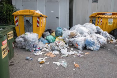 Fulls çöp bidonları nedeniyle sokaklarda çöp yığınları. Kabalık, kabalık ve kir. Bergamo, İtalya - 15 Ekim 2018