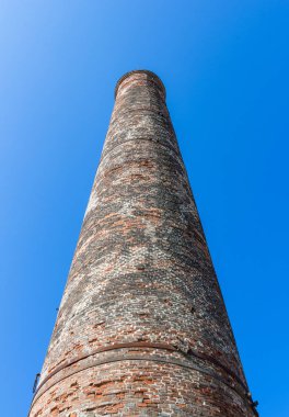 Mavi gökyüzü arka plan üzerinde izole eski tuğla baca alttan görünüm.