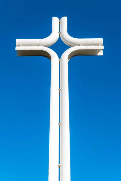 Religious christian cross made out of iron against a clear sky