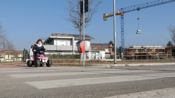 かわいい女の子は 電気グッズのクワッドに乗っています 楽しい 道路の安全性 — ストック動画