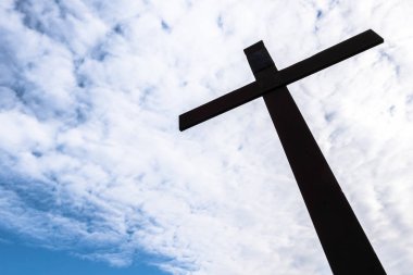 Eski paslı metal haç beyaz bulutlu mavi gökyüzüne karşı. Kavram ve olaylar için ideal. Metin için boşluk