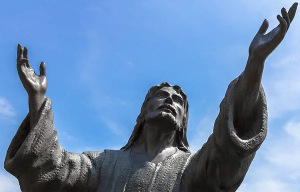 Bronzen standbeeld van Jezus kijken naar de hemel met beide armen omhoog — Stockfoto