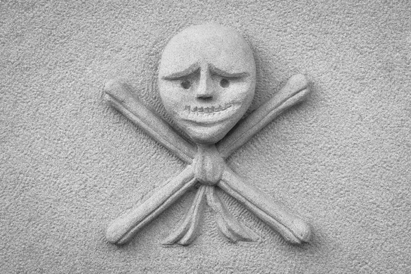Kreuzknochen in einen Grabstein geschnitzt — Stockfoto