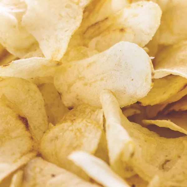 Arka plan olarak sarı tuzlu patates cipsi. Çıtır çıtır altın desenli.