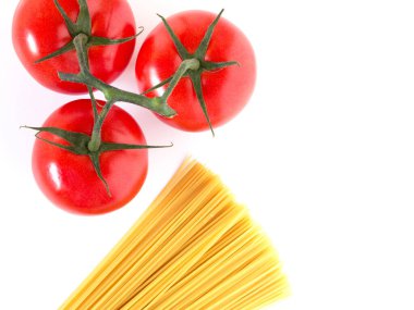 Beyaz arka planda çiğ spagetti ve domatesli makarna hazırlıyorum. Üst Manzara. Boşluğu kopyala.