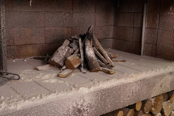 Şömine odunları küllerle yanmamış.