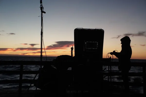 Gün batımında bir kişinin silueti kablosuz kamera kontrolü için radyo bağlantıları kuruyor 