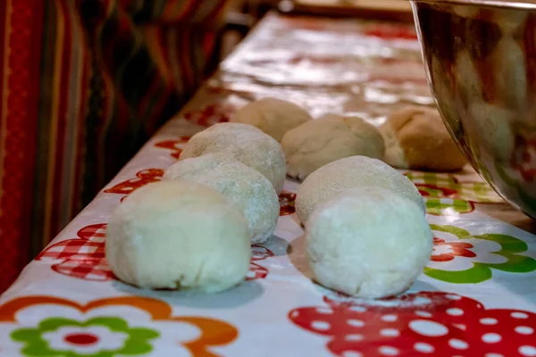 Büyükannenin mutfak masasında çiğ ekmek kütleleri var.