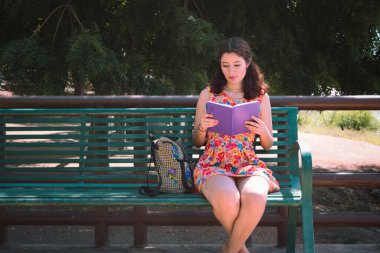 Bankta oturan ve notlar okuyan bir kız..