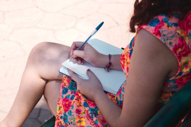 Bankta oturan kız yazıyor..