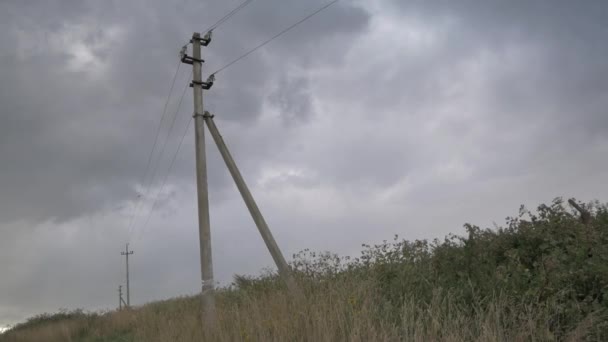 Elektro transmissies in een veld aan de horizon bij winderig bewolkt weer — Stockvideo