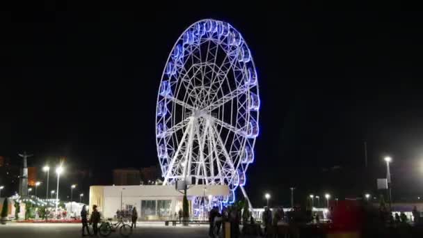 Het reuzenrad 's nachts in het park met drukke mensen — Stockvideo