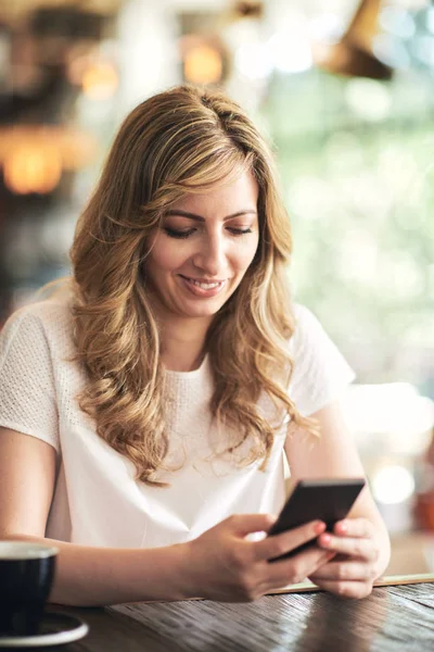 kafede oturan ve smartphone kullanarak sarışın genç kadın