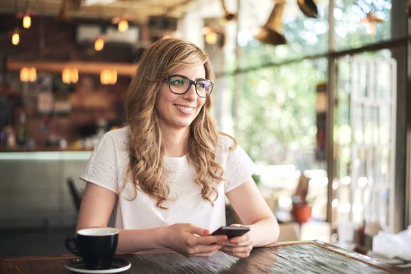 カフェに座っていると スマート フォンを使用して若いブロンドの女性 — ストック写真