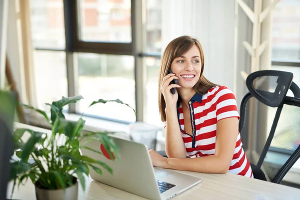 Junge Frau Spricht Mit Smartphone Während Sie Mit Laptop Tisch — Stockfoto