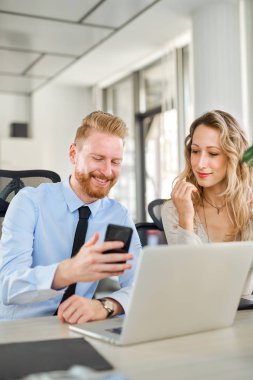 Ofiste çalışan iki arkadaşları, o bir şey ona onun Smartphone'da gösteriyor
