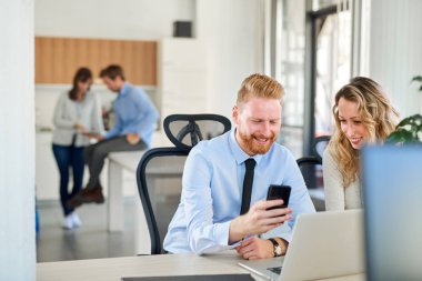 Ofiste çalışan iki arkadaşları, o bir şey ona onun Smartphone'da gösteriyor